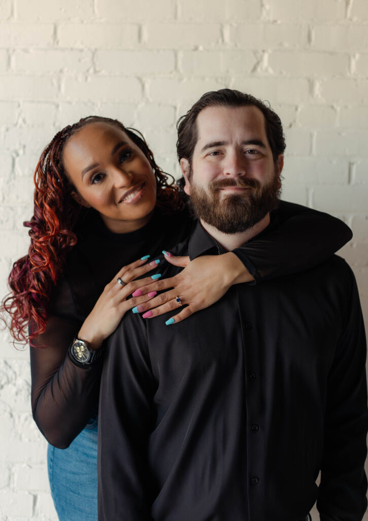 Engaged woman embracing her fiancé during a cozy studio engagement session in Augusta, Georgia