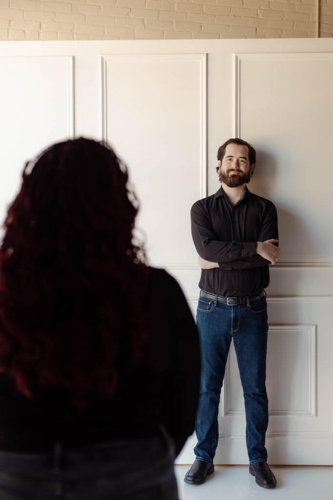 A man looks at his fiancée with a smile at a studio engagement session in Augusta, Georgia