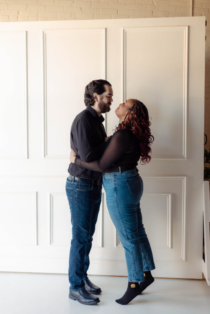 Engaged couple standing close and smiling during their studio engagement session in Augusta, Georgia