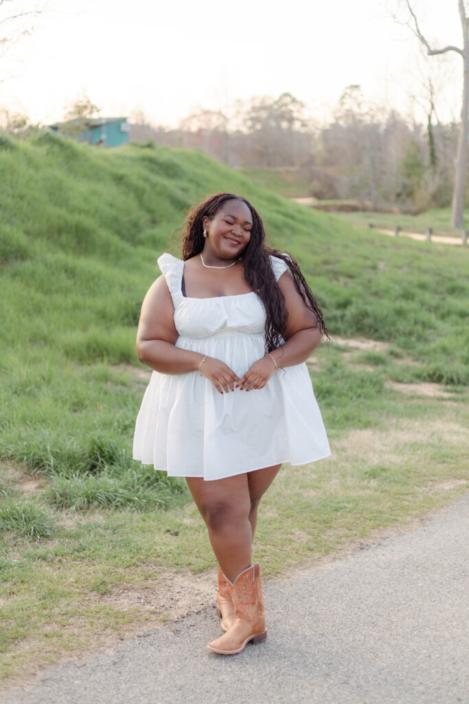College graduate wearing a white dress and cowboy boots for photo session in Augusta, Georgia