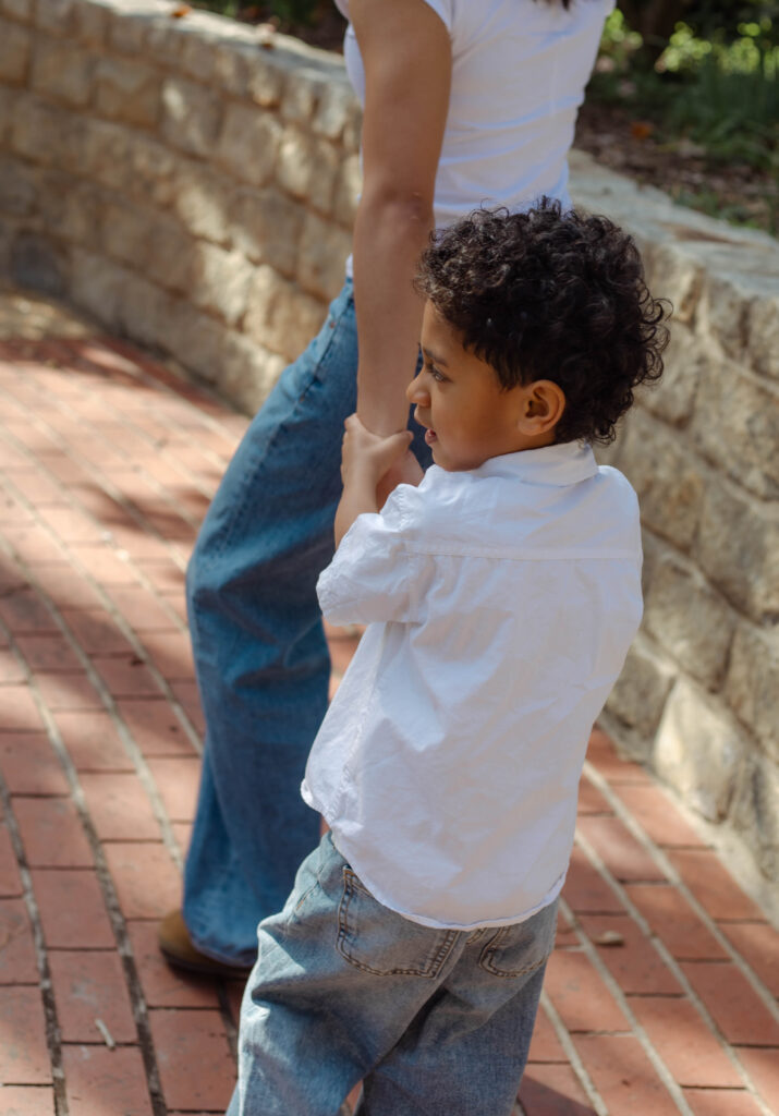 Son hanging onto his mother's arm at photo session in Augusta, Georgia