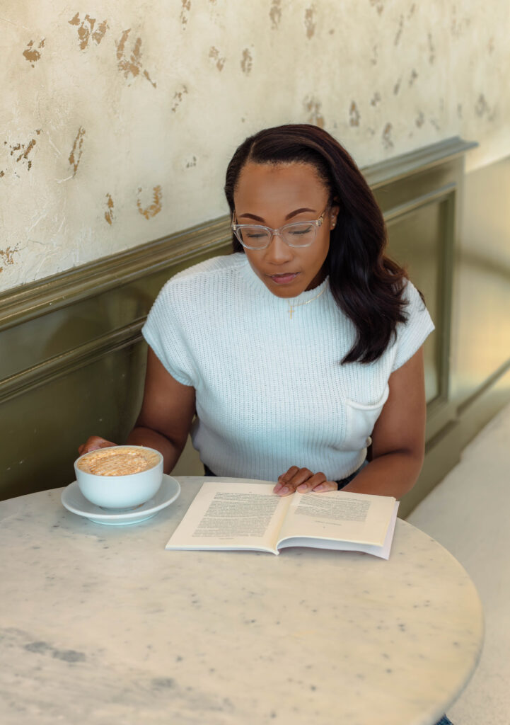 Author reading her book with a cup of coffee in hand at branding session