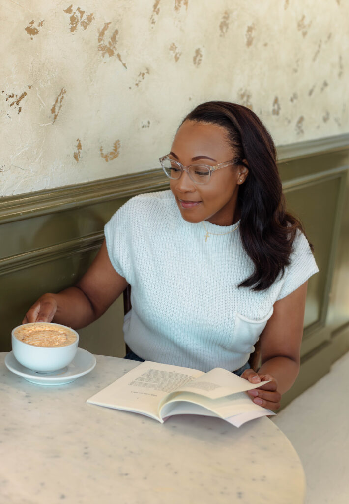 Author smiling while holding her book and coffee at a branding session