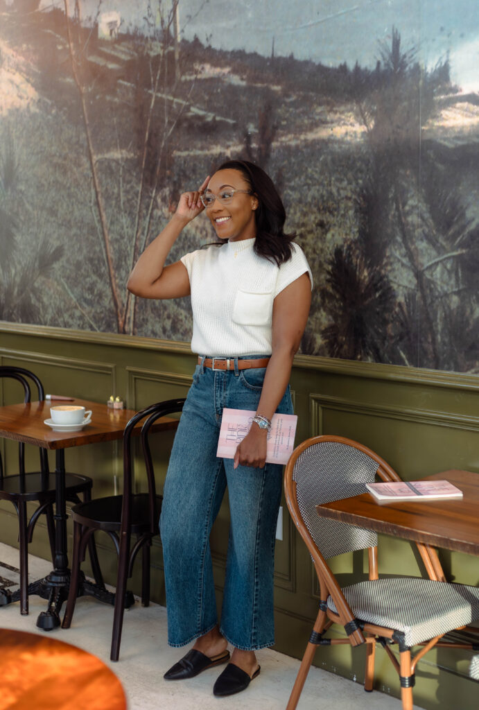 Author standing and holding her book during a branding photoshoot at Rooted Coffeehouse in Martinez, Georgia