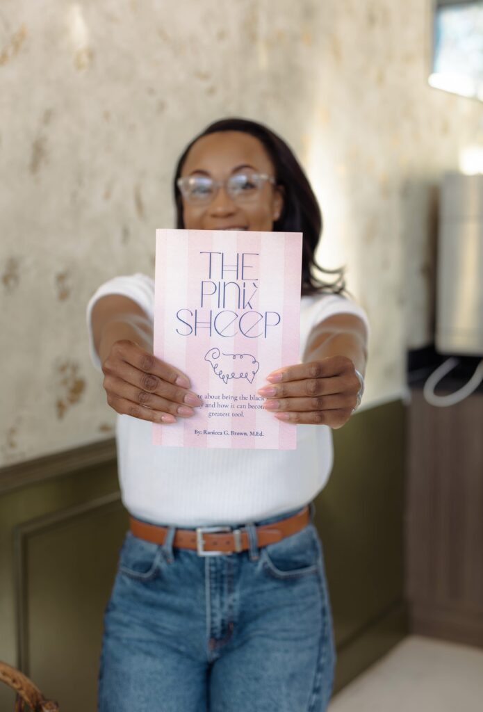 Author holding out her book in an inviting coffeehouse