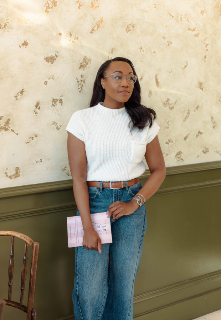 Author posing with her book in a warm, inviting coffeehouse
