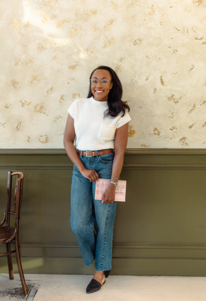 Author standing with her book during a branding photoshoot at Rooted Coffeehouse in Martinez, Georgia