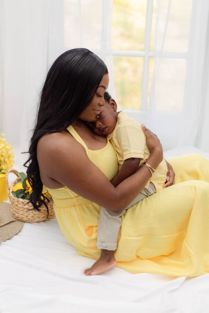 Little boy lays his head on his mother's chest while she hugs him