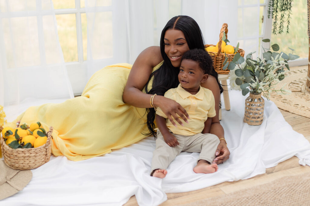 Mom and her son posed on a white sheet with lemons around