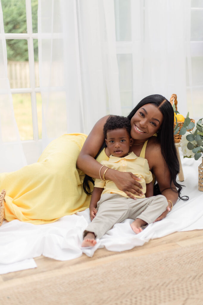 Mom holds her son while laying with a smile