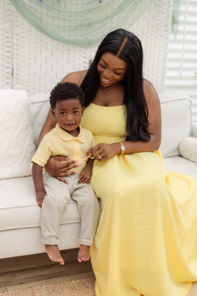 Mother and son pose while sitting on couch