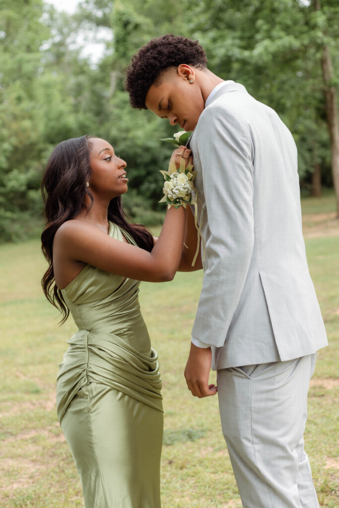 Girl helps her prom date pin boutonniere