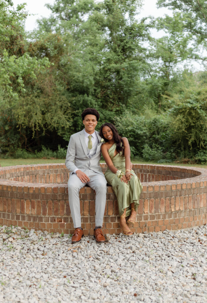 Couple sitting close while smiling for prom photos