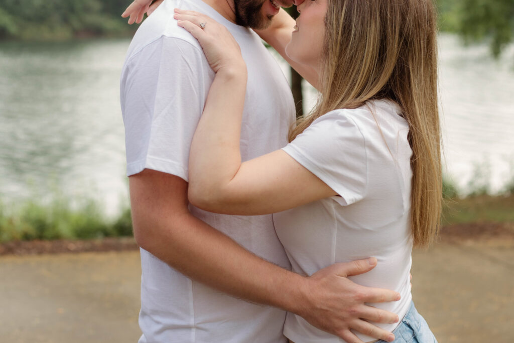 Close up photograph of a man holding his fiancée with a smile