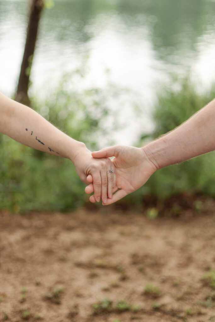 A close up of an engaged couples hands