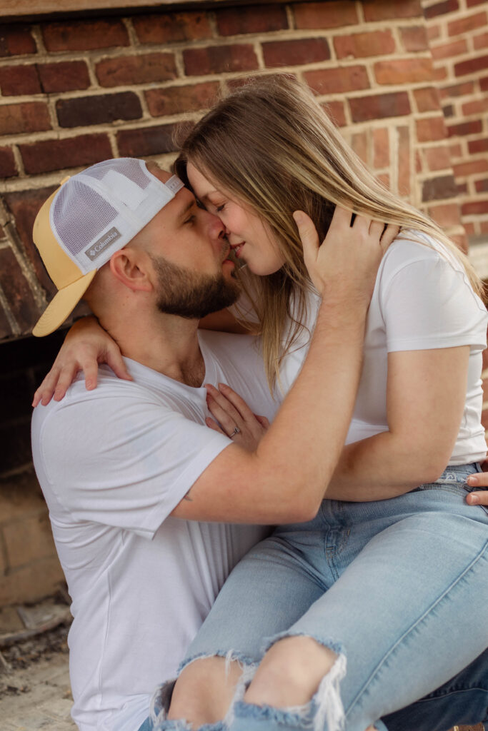 Engaged couple kisses while sitting together