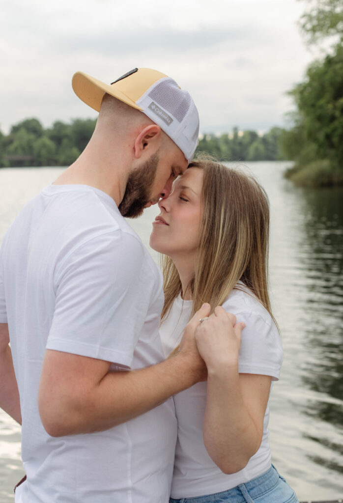 Engaged couple stands close with noses touching