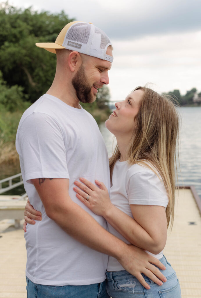 Engaged couple smiling at one another for photo session