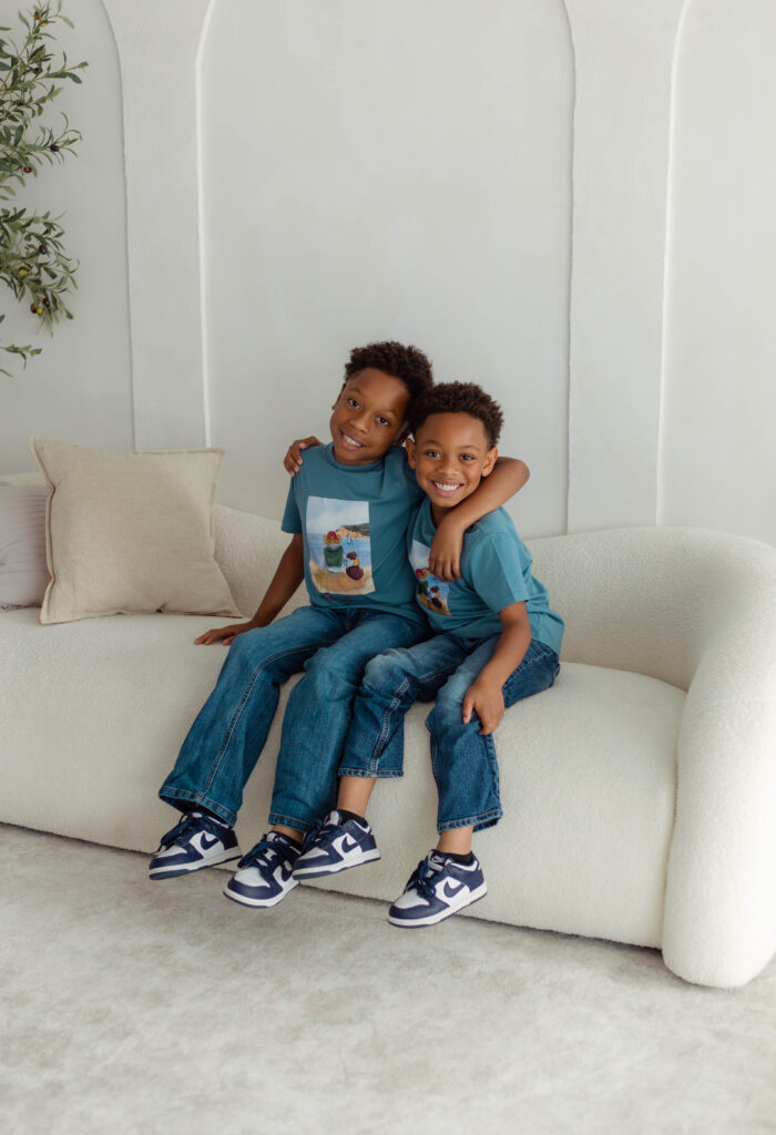 Two siblings hugging together on a couch