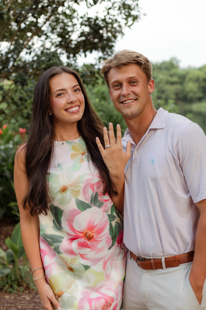 Engaged couple shows off the ring with big smiles