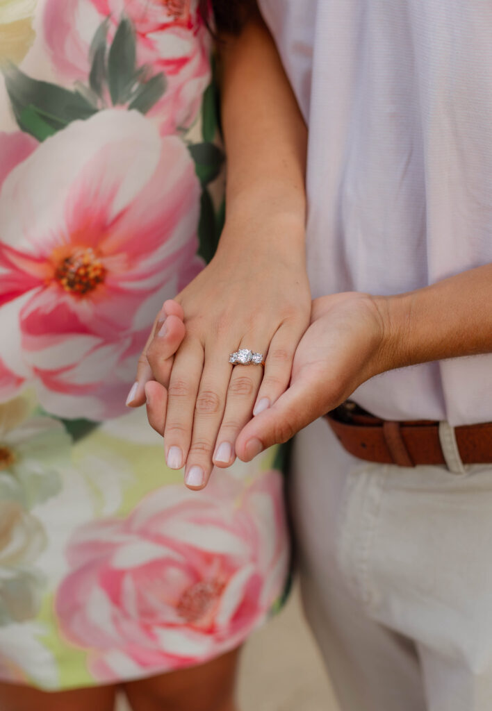 A close-up shot of the ring as couple holds hands