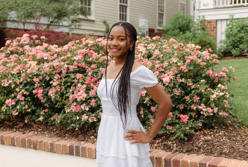 High School senior posing for photos in front of pink flowers in North Augusta, South Carolina