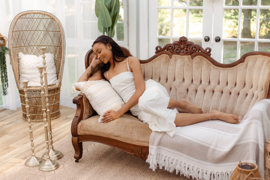 Model posing on a couch for boho themed styled shoot