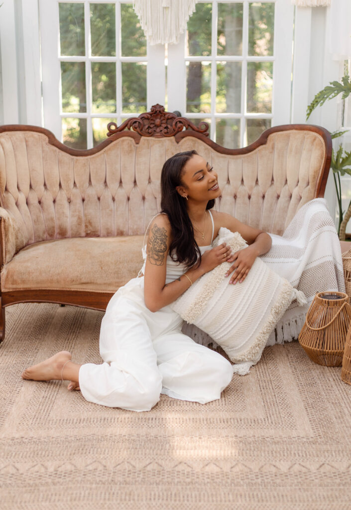 Model posing in front of vintage brown couch for boho session