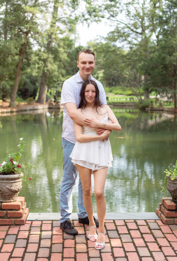 Man holds wife from behind at historic European inspired location