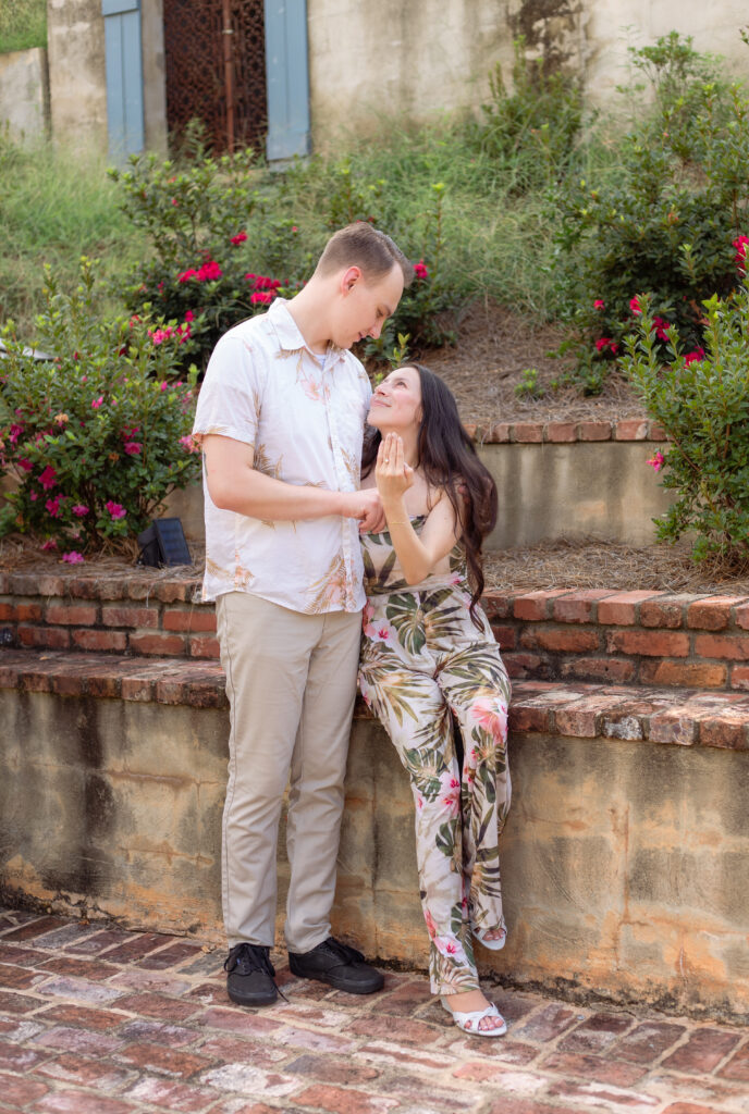 Woman shows off ring while husband holds her close