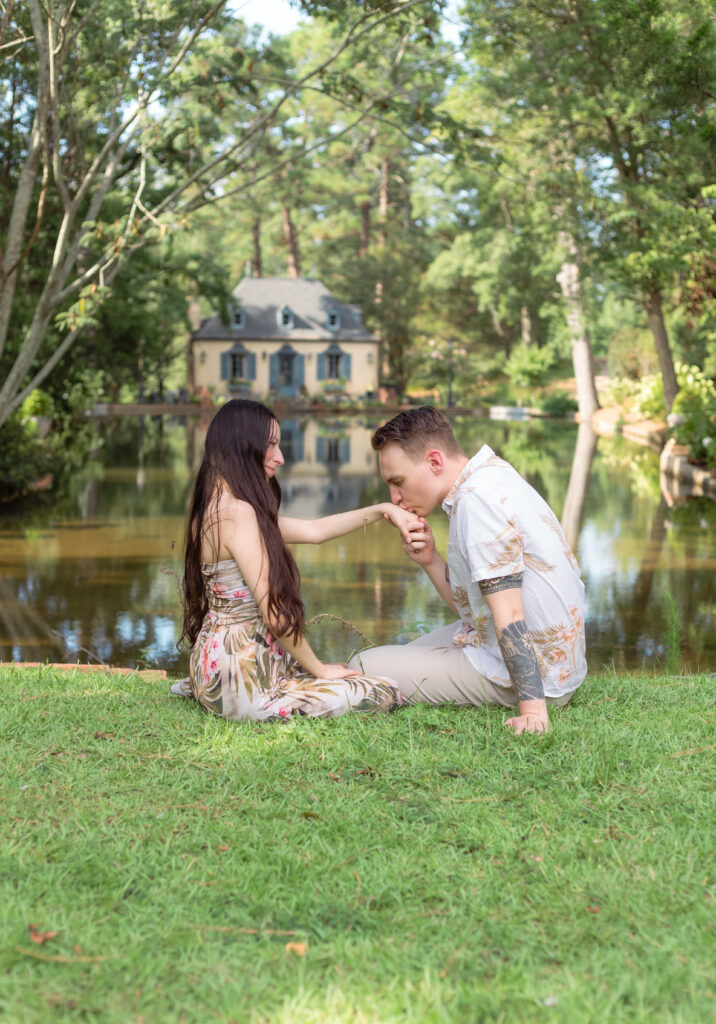 Man kisses his partner's hand at Bath Gardens