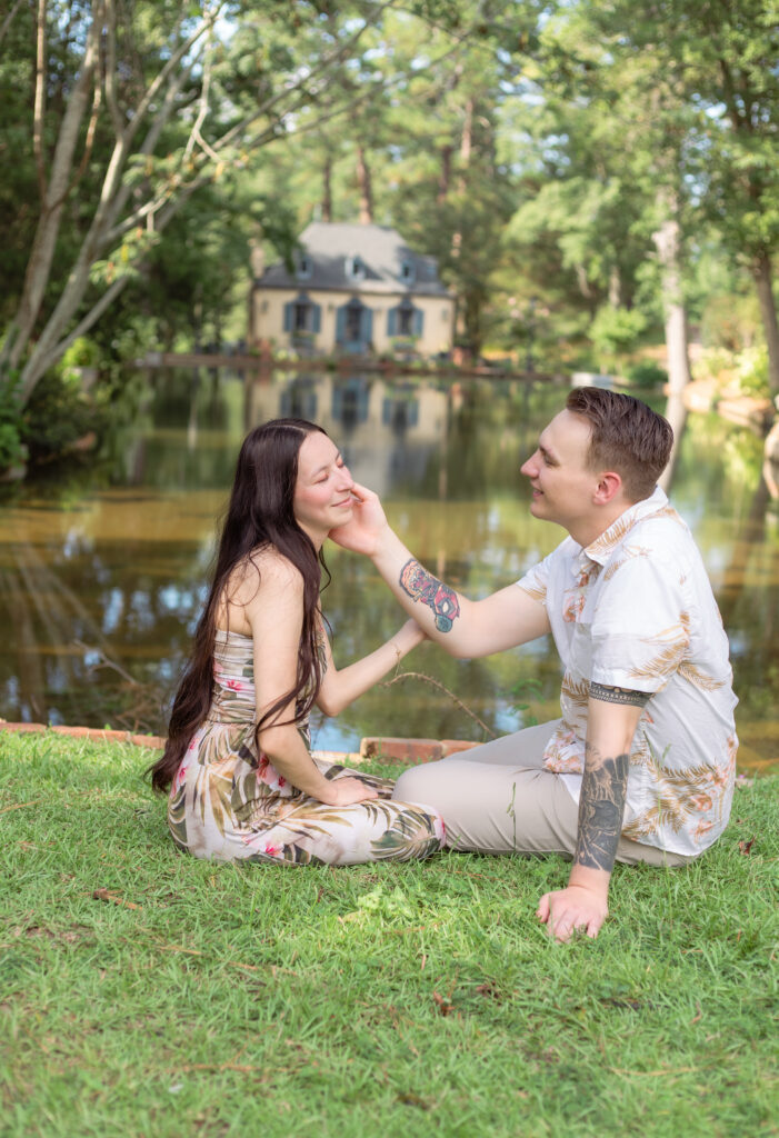 Man holds his wife's cheek in front of pond