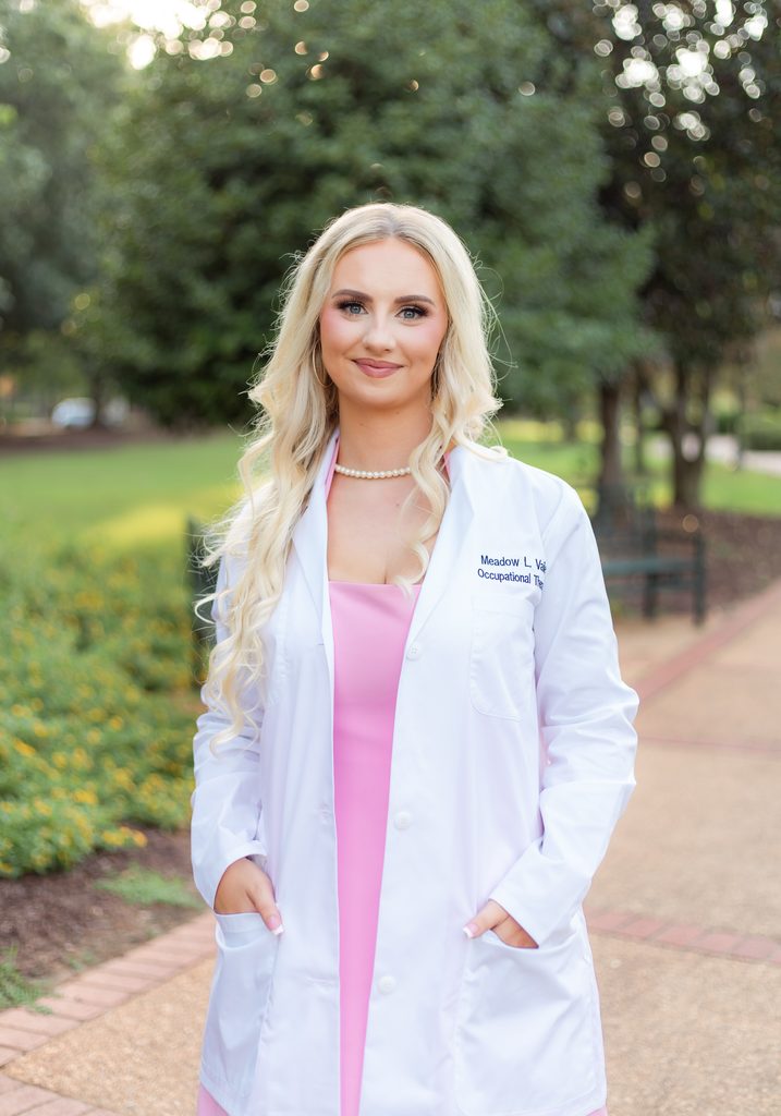 College graduate poses for photo session with white coat on
