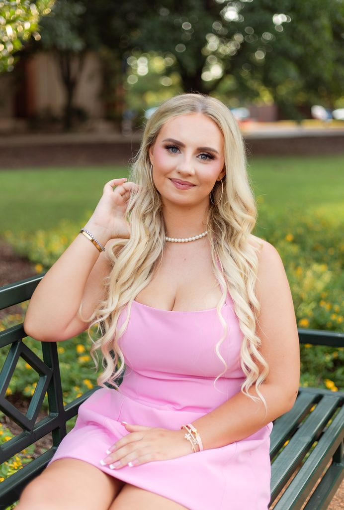Young woman tucks hair behind her ears for photo session