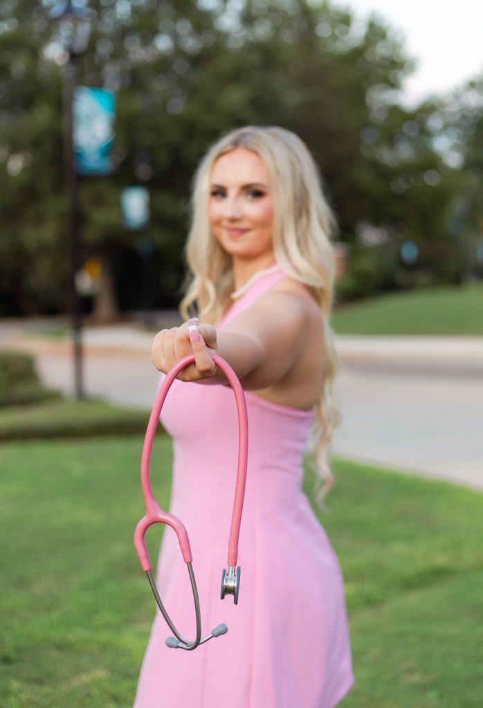 Occupational therapy college grad showing off pink stethoscope