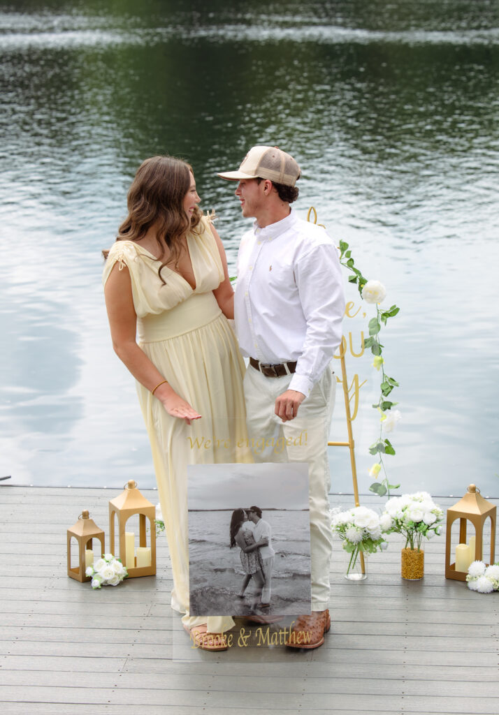 Newly engaged couple holds a sign that reads "we're engaged"