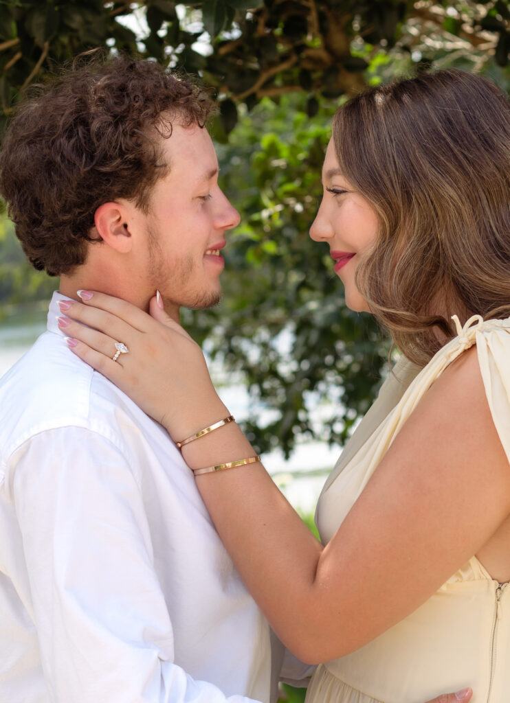Close up of an engaged couple smiling at one another