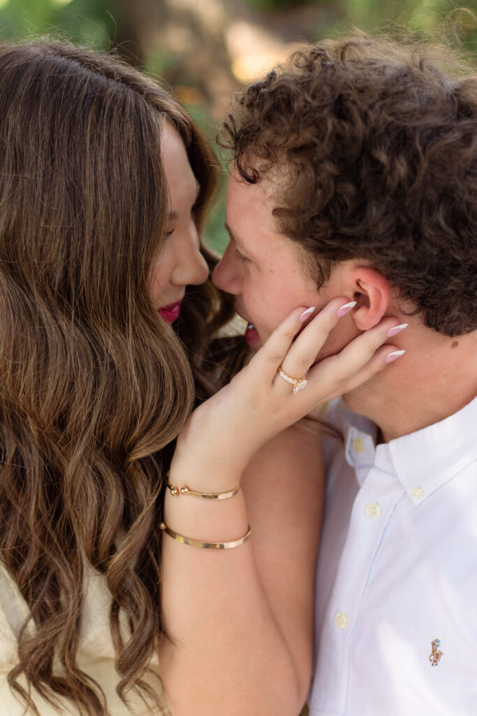 Close up of an engaged couple while fiancée holds his face