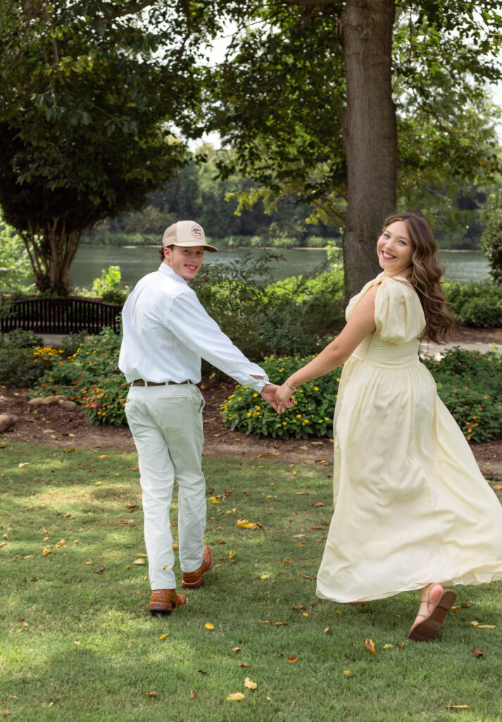 Engaged couple run off while smiling at the camera